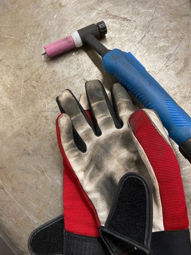 Schweißbrenner und Schutzhandschuhe am Arbeitsplatz